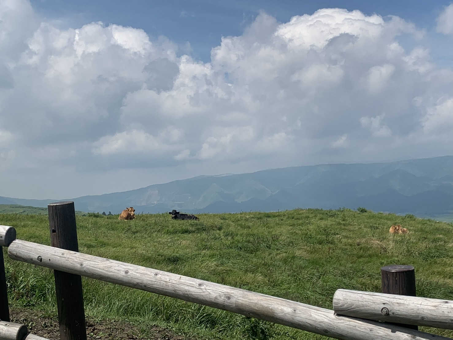 青空と雲の下に広がる草原と山並み